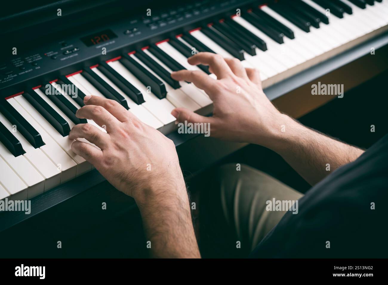 Mani maschili che suonano Un piano digitale Foto Stock
