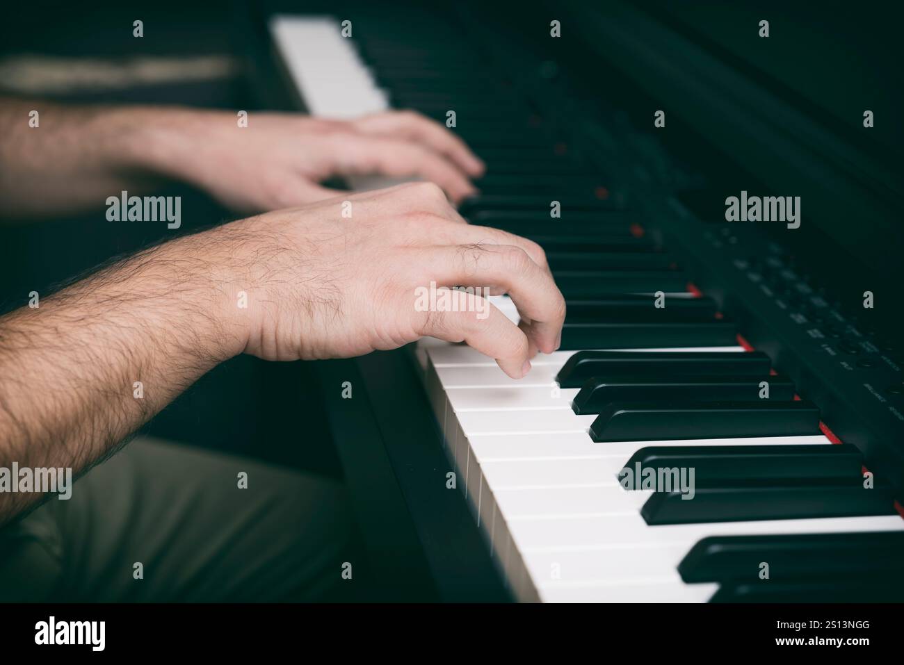 Mani maschili che suonano Un piano digitale Foto Stock