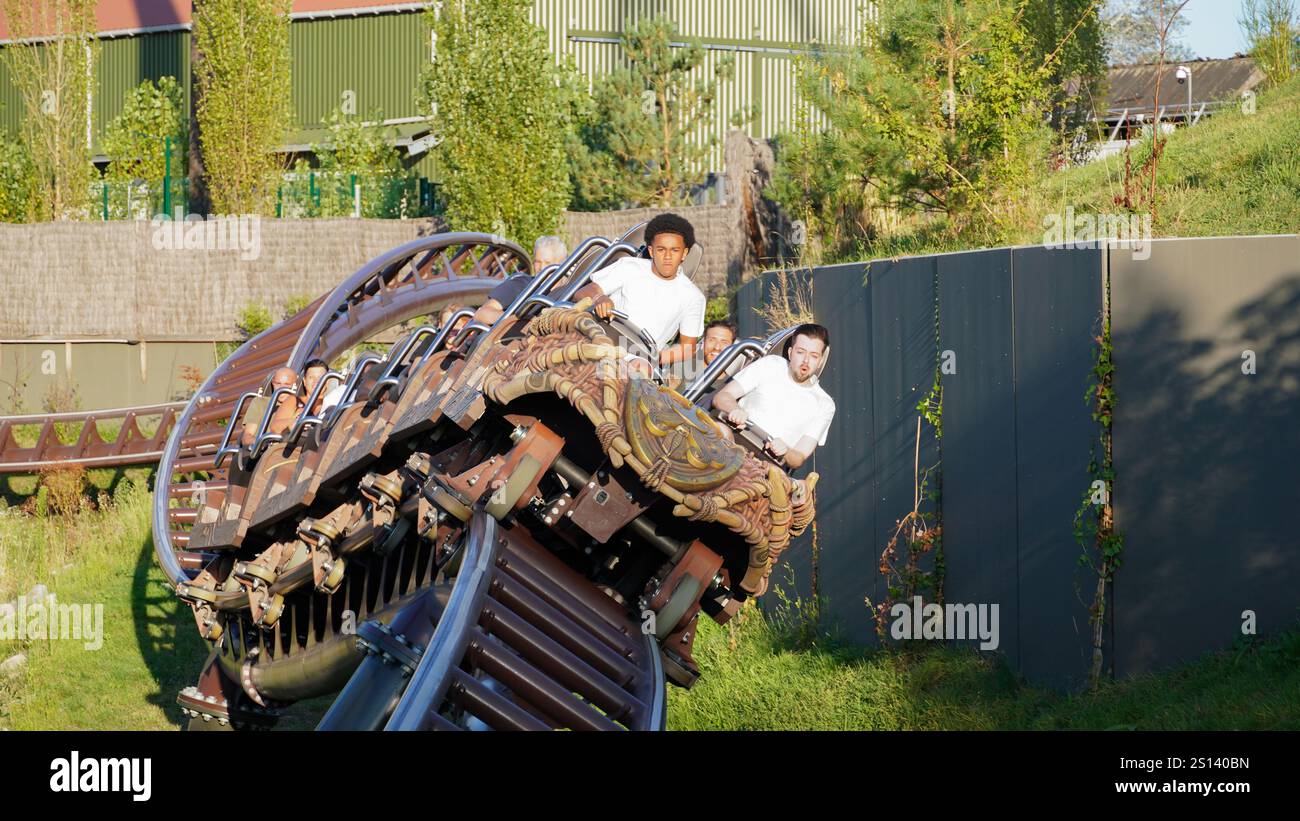 I giovani si divertono sulla curva delle montagne russe di lancio intense «Toutatis» del produttore «Intamin» nel parco tematico «Asterix» Foto Stock
