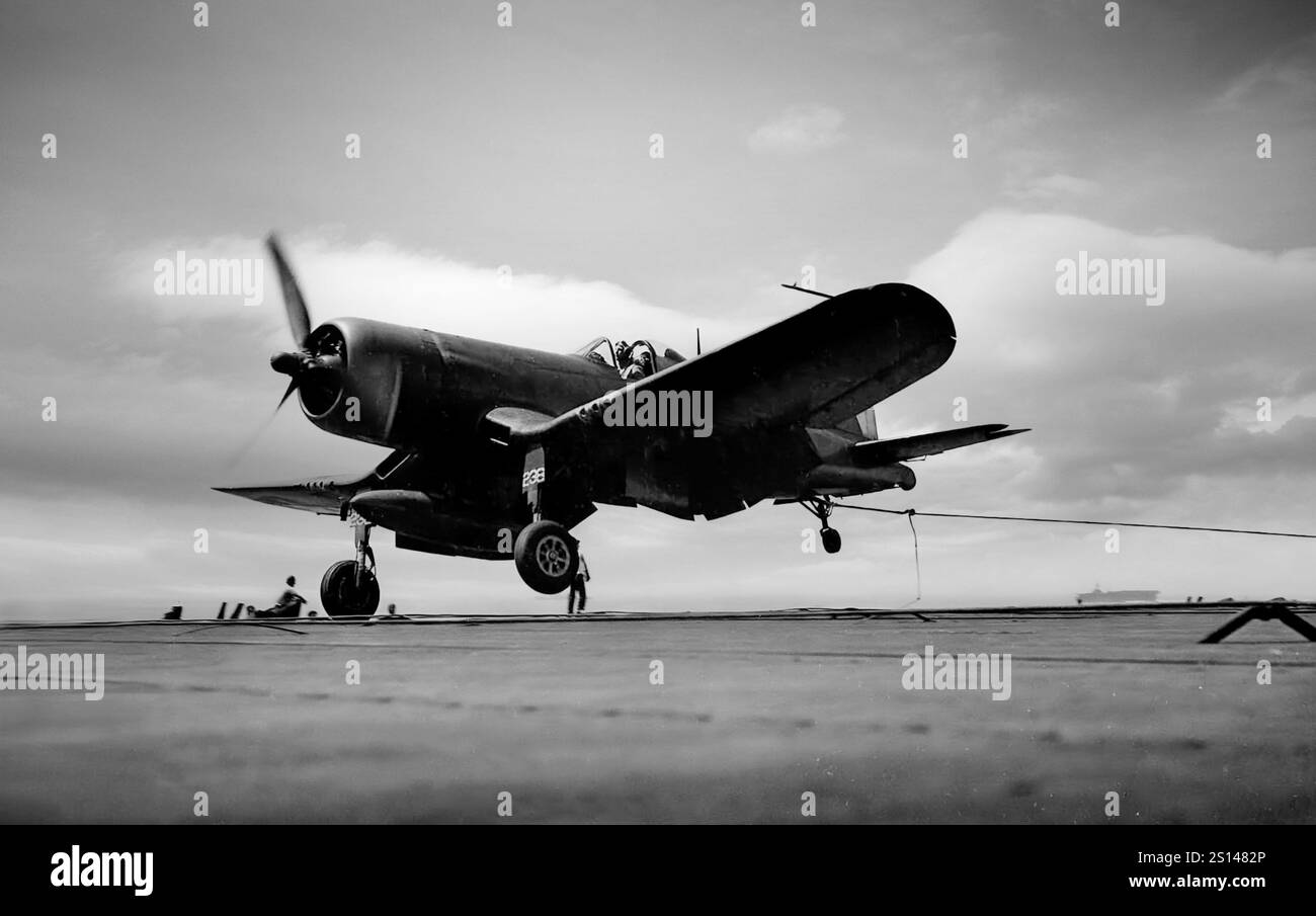 Un Vought F4U Corsair cattura il filo durante l'atterraggio di un vettore. Un aereo da caccia americano principalmente della seconda guerra mondiale e della guerra di Corea, fu progettato e utilizzato principalmente come aereo da portaerei con la Marina e i Marines degli Stati Uniti. Uno dei caccia-bombardieri portaerei più capaci della guerra, alcuni piloti giapponesi lo consideravano il caccia americano più formidabile. Il Corsair servì quasi esclusivamente come caccia-bombardiere durante la guerra di Corea e durante le guerre coloniali francesi in Indocina e Algeria. Foto Stock