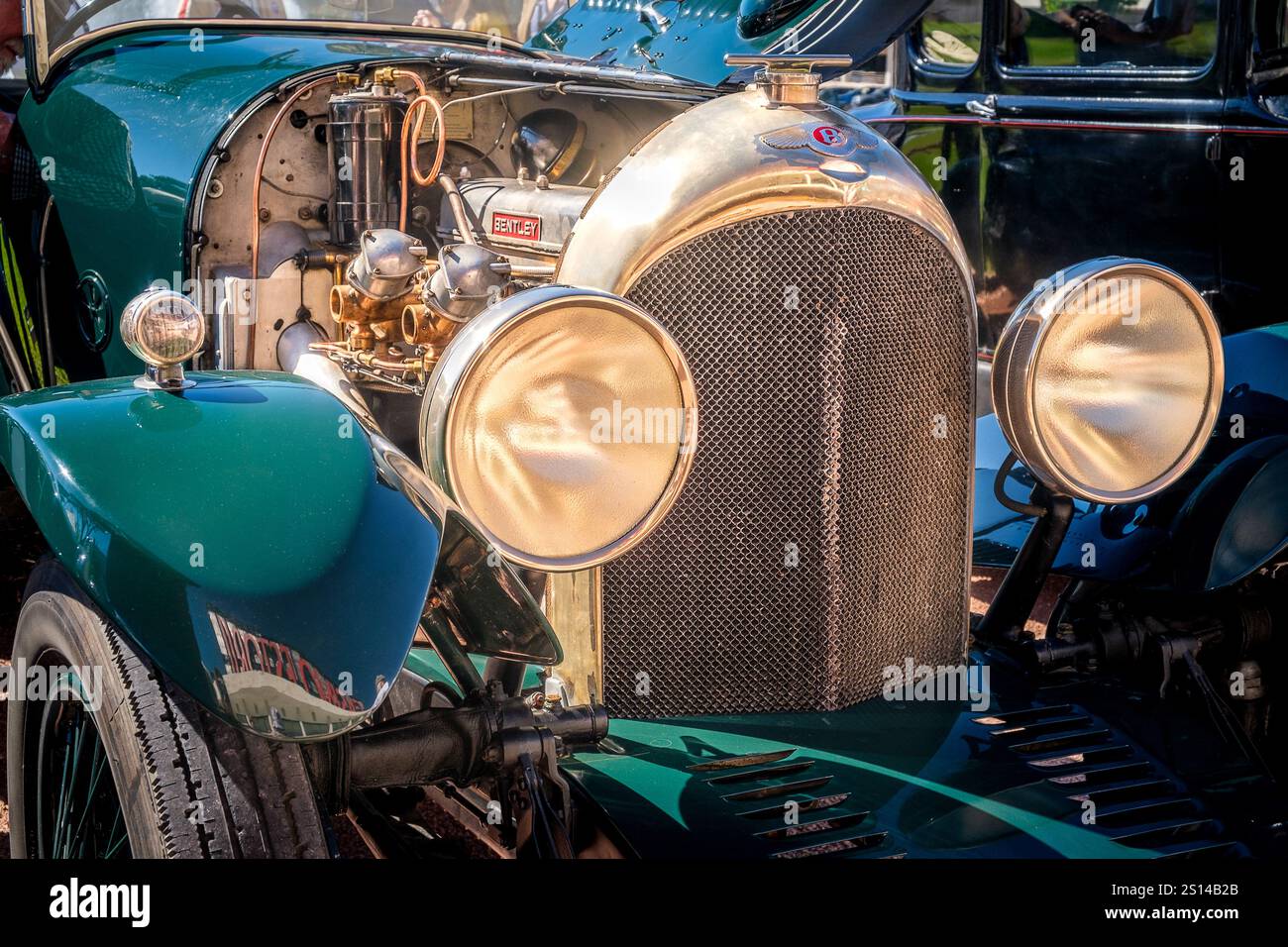 Lisbona, Portogallo - 29 settembre 2024: Parte frontale di Bentley 4 Seater Sports Taylor d'epoca in un'ottica selettiva. Vecchi fari grandi, griglia del radiatore e cofano aperto che mostrano un motore d'epoca, i suoi componenti, carburatori e superfici lucide. Foto Stock