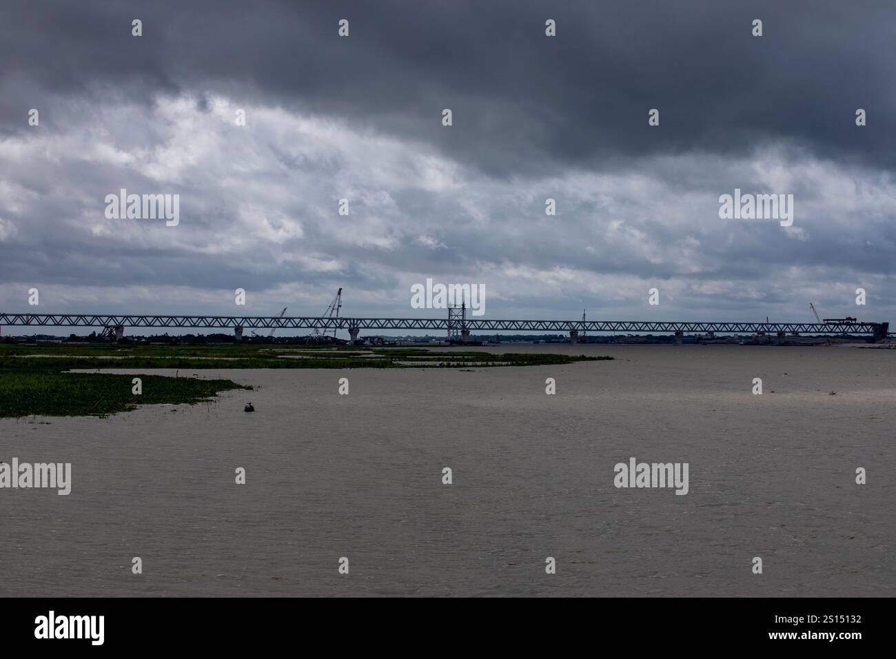 26 luglio 2019: Munshiganj, Bangladesh: Lavori di costruzione del Padma Multipurpose Bridge attraversa il fiume Padma sotto un cielo nuvoloso. Foto Stock
