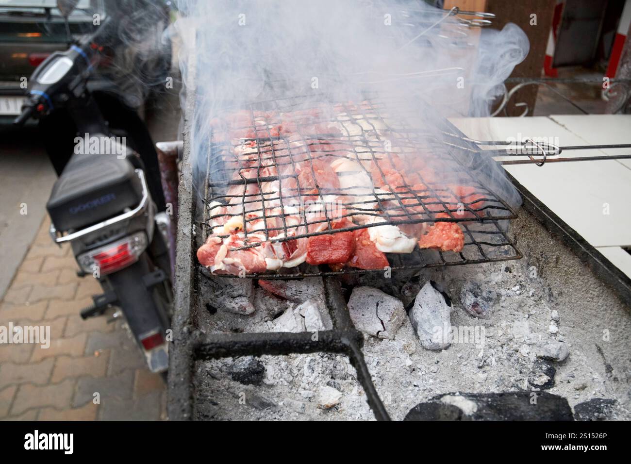 cucinare carne sul ciglio della strada in un caffè su carbone caldo cucinando all'aperto imlil morocco Foto Stock