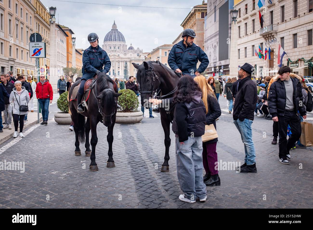 Roma, RM, Italia. 31 dicembre 2024. La vigilia di Capodanno, cittadini e turisti affollano via della conciliazione, la principale strada di accesso alla città del Vaticano e alla Basilica di San Pietro, per una passeggiata in attesa della celebrazione di stasera. La polizia a cavallo e i Carabinieri pattugliano la zona e interagiscono con i passanti. (Credit Image: © Marco di Gianvito/ZUMA Press Wire) SOLO PER USO EDITORIALE! Non per USO commerciale! Foto Stock