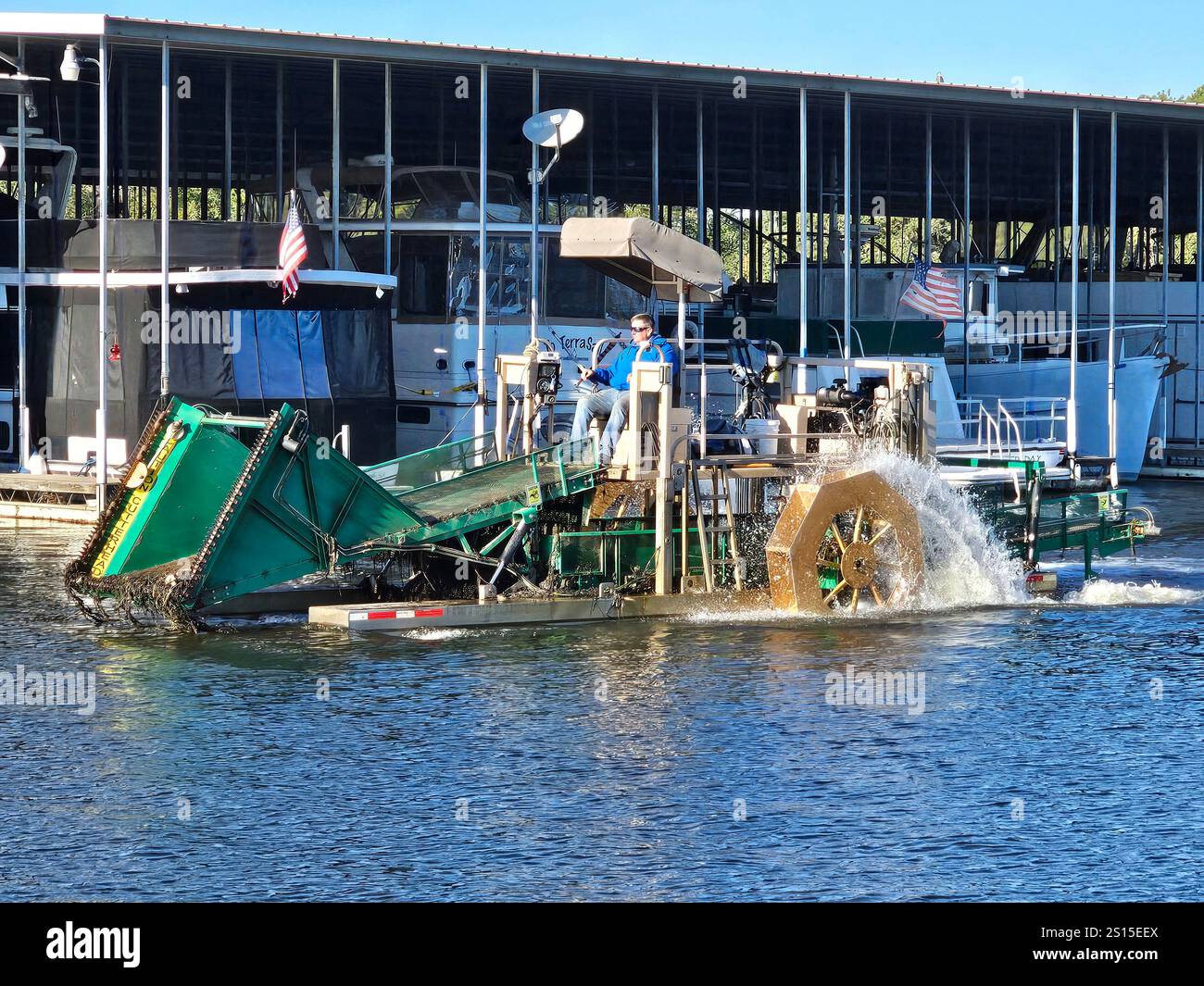 Macchina per tagliare erba. Controllo delle erbacce acquatiche in un porticciolo in Alabama. Foto Stock