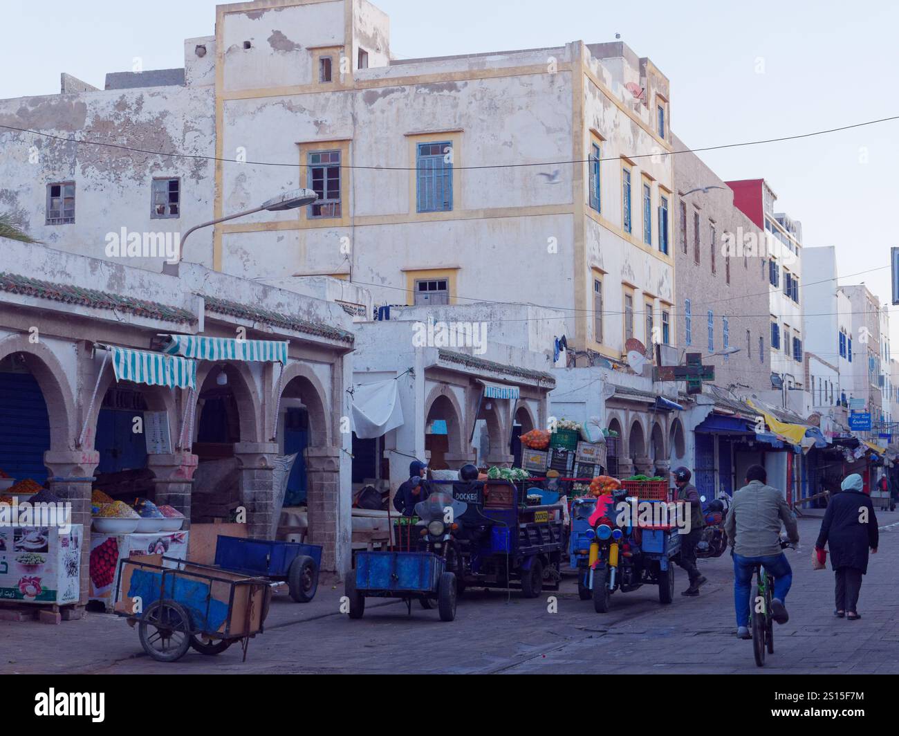 Biciclette a motore che trasportano carretti di prodotti nel mercato della Medina al mattino. Essaouira, 31 dicembre 2024 Foto Stock