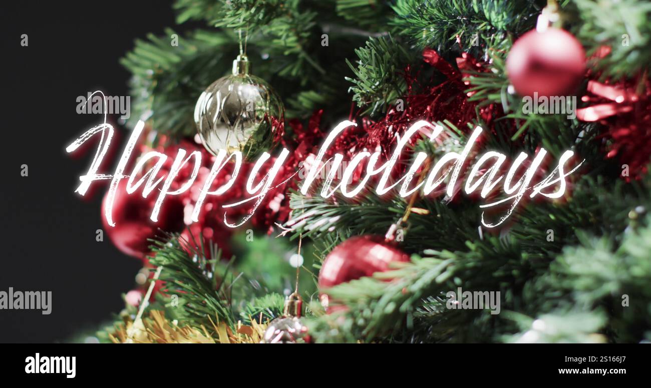 Buone feste testo in bianco sulle decorazioni sull'albero di natale su nero Foto Stock