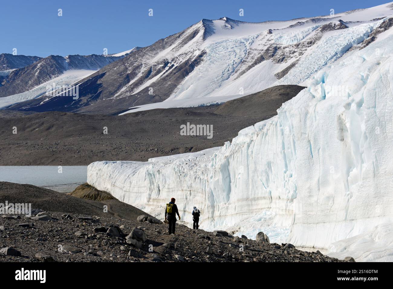 Due persone camminano lungo il ghiacciaio Taylor, la Taylor Valley, le McMurdo Dry Valleys, l'Antartide, verso il lago Bonney sottostante. Foto Stock