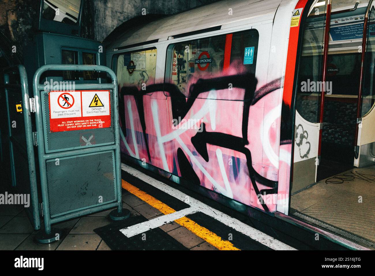 Treno metropolitano urbano con opere d'arte di graffiti rosa alla stazione della città Foto Stock