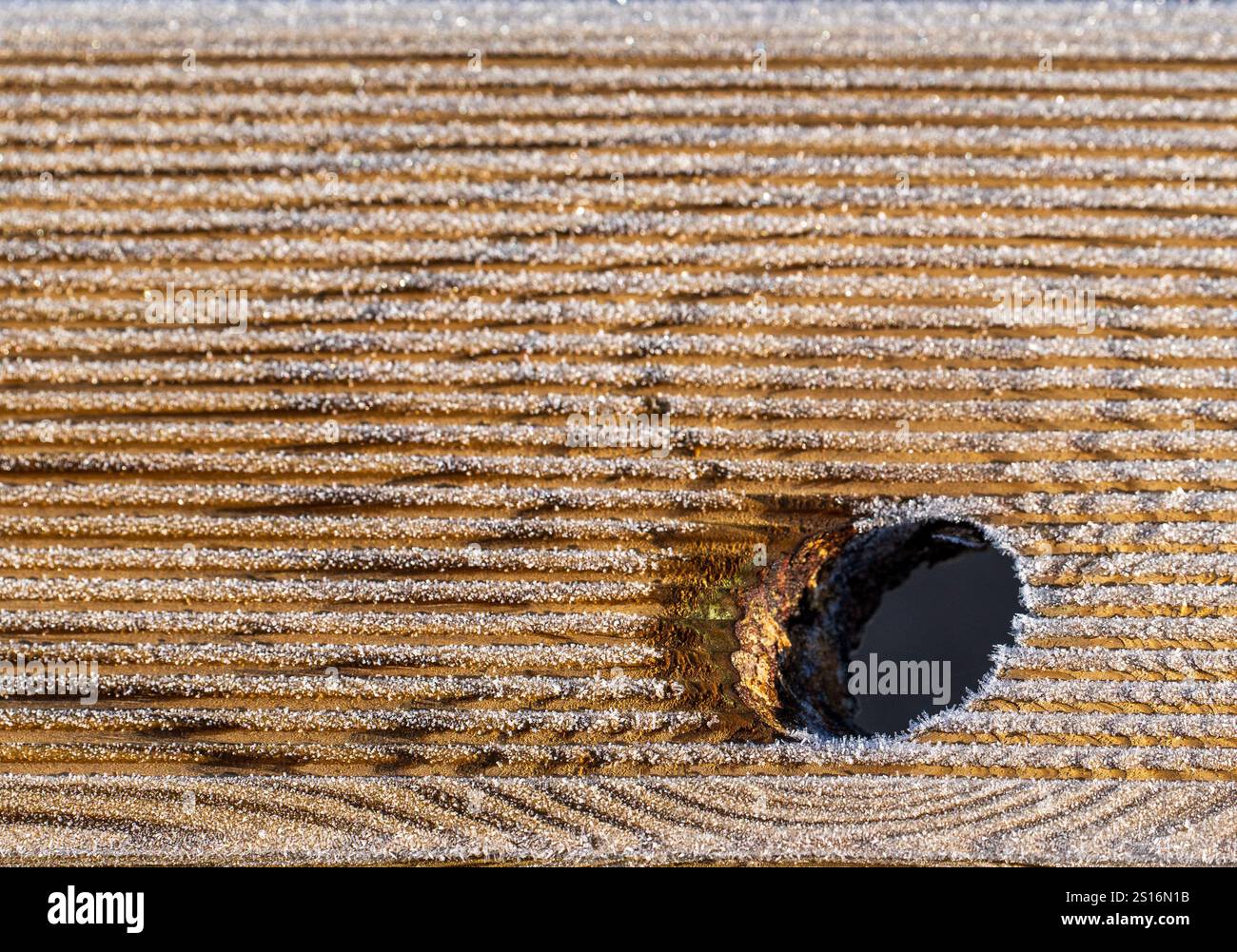 Frosty Hole in Yellow Wooden Plank Foto Stock