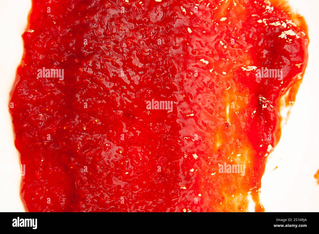 La marmellata di fragole si diffonde da vicino con pezzi e un angolo superiore di consistenza. Foto Stock