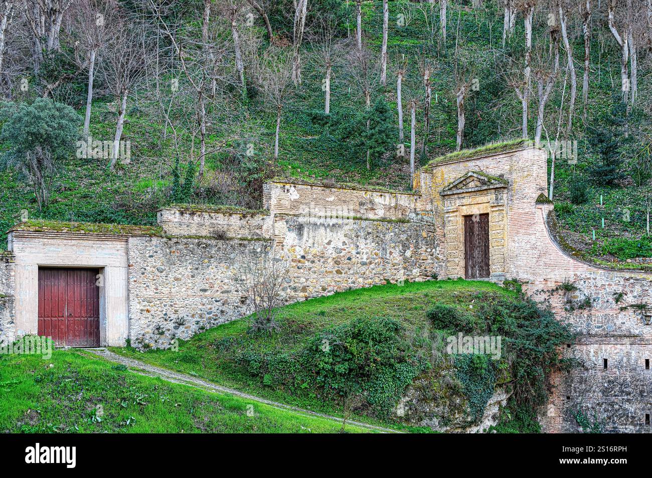 Antiche porte e muri in pietra, parte delle fortificazioni dell'Alhambra lungo la cresta montuosa. Foto Stock