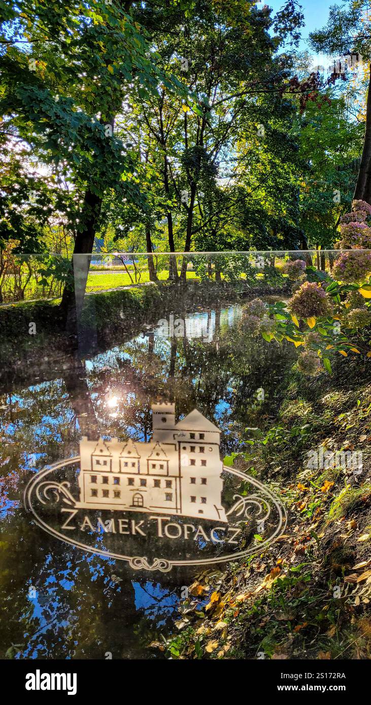 Il logo dello Zamek Topacz sullo sfondo di alberi e fiumi nel parco. 28 ottobre 2023. Wrozlaw, Polonia. Foto Stock