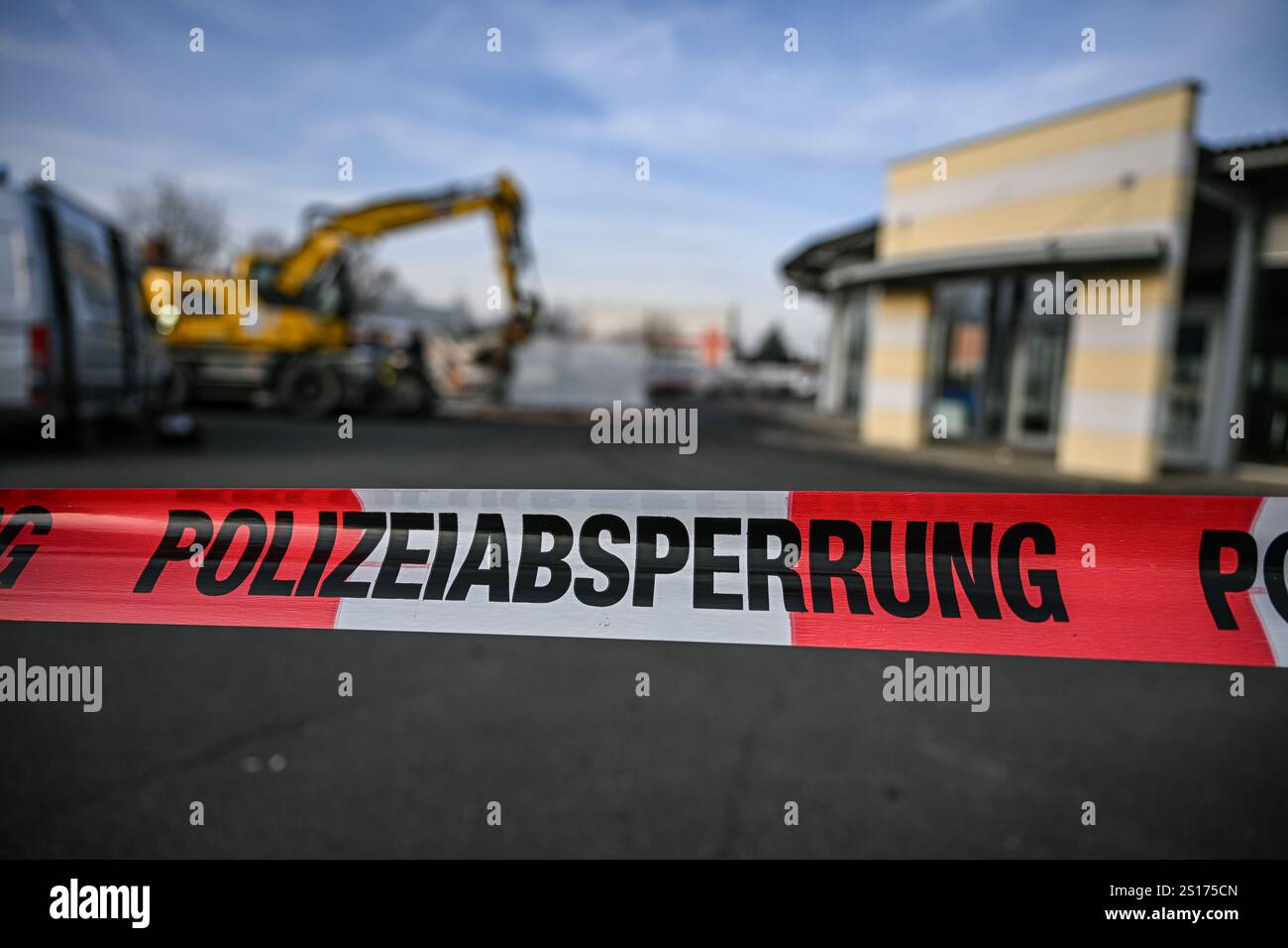 01 gennaio 2025, Baden-Württemberg, Tauberbischofsheim: Un escavatore si trova dietro un cordone della polizia vicino a una concessionaria di auto a Tauberbischofsheim dopo un viaggio distruttivo. A seguito della distruttiva guida dell'escavatore e della sparatoria fatale della polizia al conducente nel nord-est del Baden-Württemberg, sono in corso indagini sull'incidente. Dato che l'autista è morto, l'indagine sul movente potrebbe richiedere ancora più tempo, ha detto un portavoce della polizia. Il pomeriggio di Capodanno, il tedesco di 38 anni aveva sequestrato un escavatore nella piccola città Franconica di Grünsfeld (distretto Main-Tauber), RAM Foto Stock 01 gennaio 2025, Baden-Württemberg, Tauberbischofsheim: Un escavatore si trova dietro un cordone della polizia vicino a una concessionaria di auto a Tauberbischofsheim dopo un viaggio distruttivo. A seguito della distruttiva guida dell'escavatore e della sparatoria fatale della polizia al conducente nel nord-est del Baden-Württemberg, sono in corso indagini sull'incidente. Dato che l'autista è morto, l'indagine sul movente potrebbe richiedere ancora più tempo, ha detto un portavoce della polizia. Il pomeriggio di Capodanno, il tedesco di 38 anni aveva sequestrato un escavatore nella piccola città Franconica di Grünsfeld (distretto Main-Tauber), RAM Foto Stock