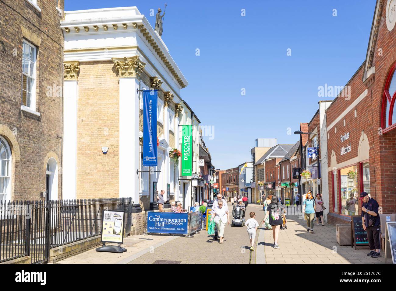 Huntingdon, The Commemoration Hall, teatro e negozi con gente che fa shopping sulla High Street, nella piccola città di Huntingdon, Cambridgeshire, Inghilterra, Regno Unito Foto Stock