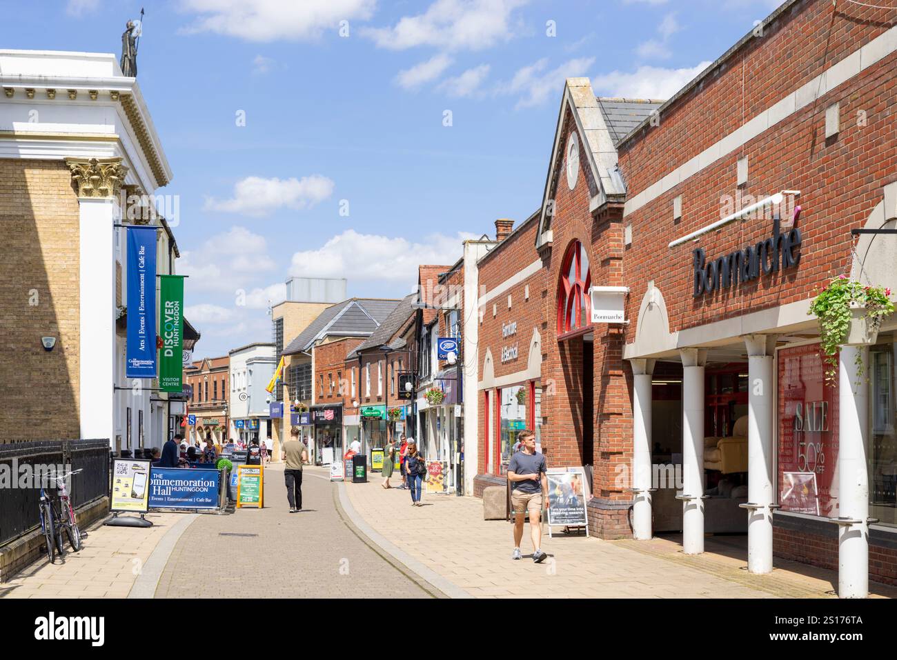 Huntingdon, The Commemoration Hall, teatro e negozi con gente che fa shopping sulla High Street, nella piccola città di Huntingdon, Cambridgeshire, Inghilterra, Regno Unito Foto Stock