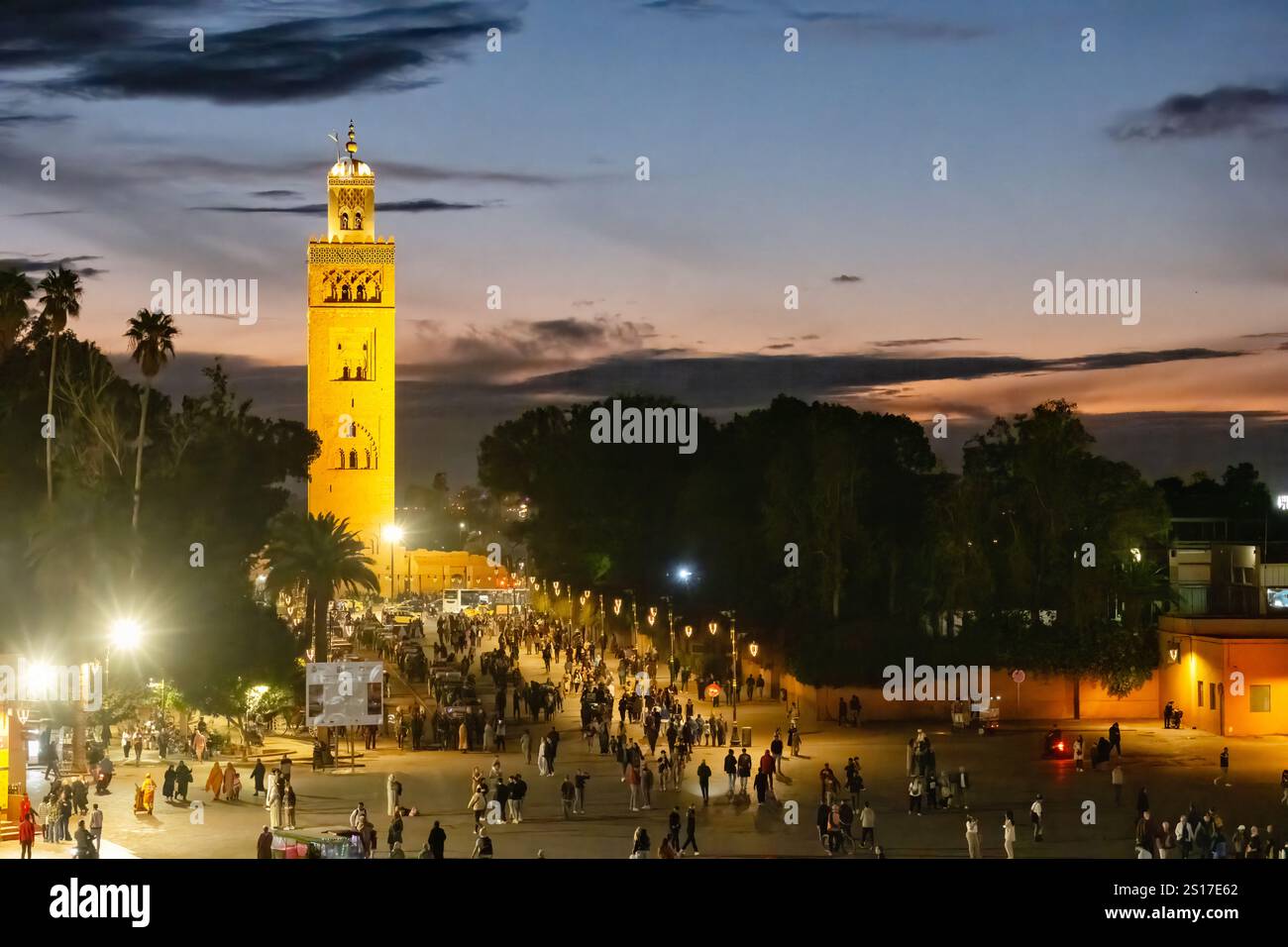 Marrakech, Marocco. Una vista della moschea Kutubiyya situata nella medina di Marrakech. La vista e' nelle prime ore della sera da un affollato Jemaa el-Fnaa Foto Stock