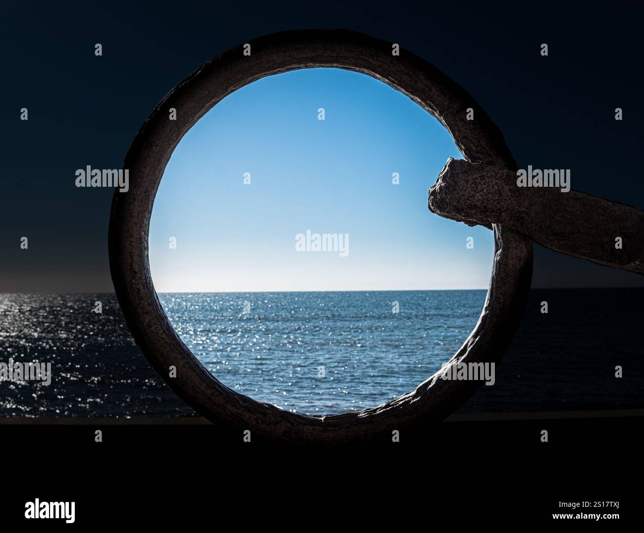 Telaio circolare in ferro da un'ancora di fronte alla vista blu del mare e del cielo Foto Stock
