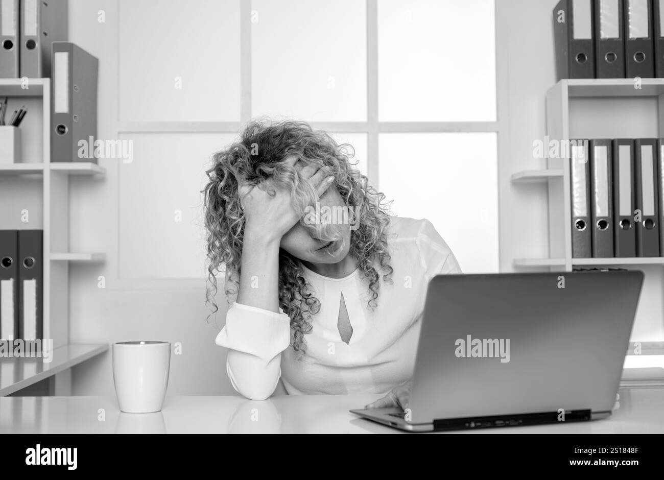 Lavoratore in ufficio stanco. Donna pigra annoiato utilizzando il computer portatile al mattino, noioso in ufficio Foto Stock