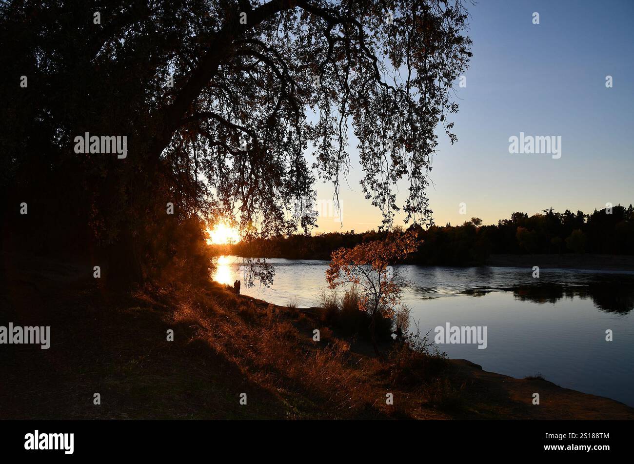 Una coppia gode della bellezza del fiume American, in mostra durante il tramonto l'11 novembre 2024. Il distretto di Sacramento del corpo degli ingegneri dell'esercito degli Stati Uniti sta lavorando per preservare la bellezza della zona, laddove possibile, e al contempo sta adottando misure per proteggere il pubblico dall'erosione e dalle inondazioni. Foto Stock