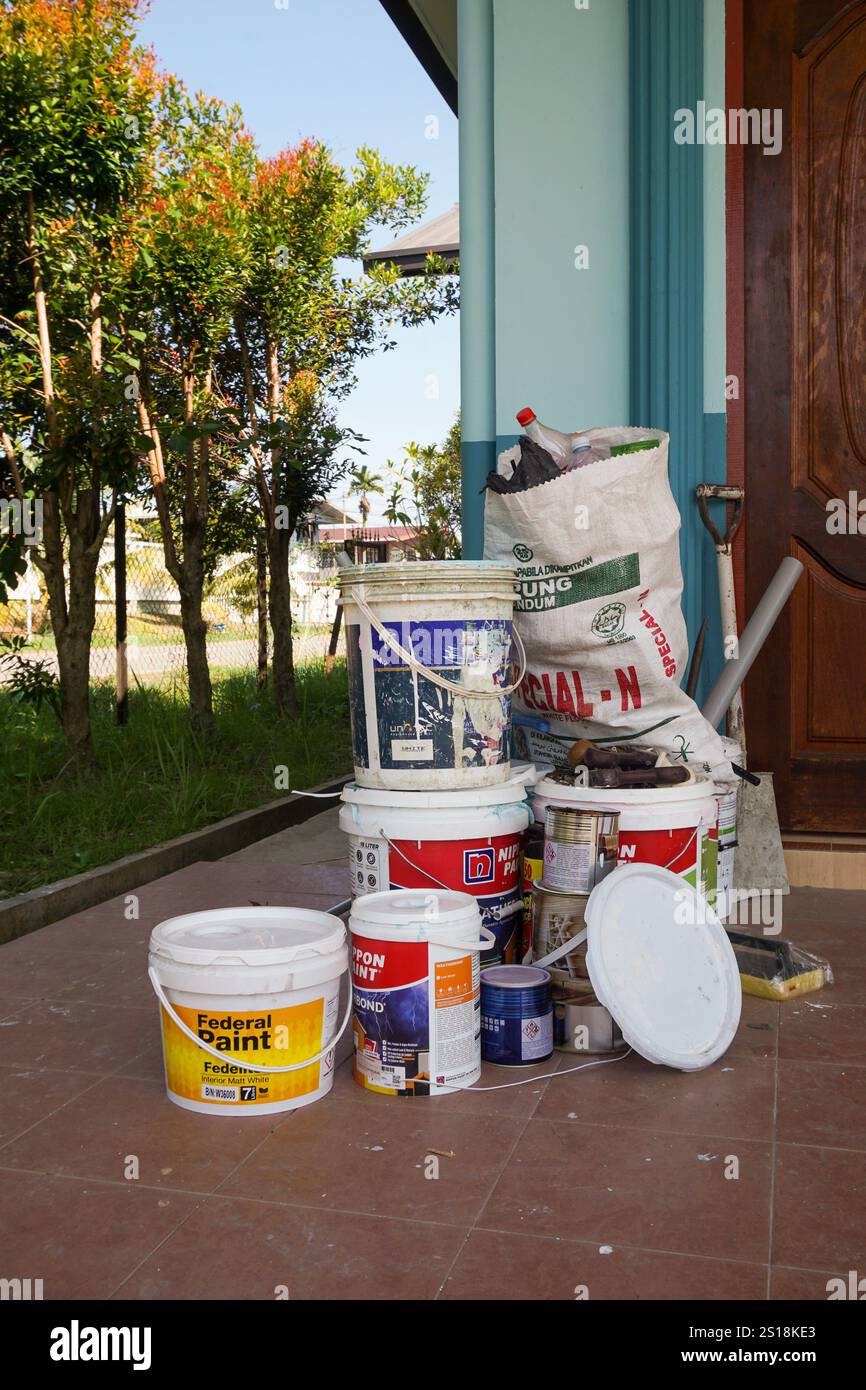 Kota Kinabalu, Sabah. Malesia. Presa in considerazione il 17 ottobre 2023. Lattine di plastica vuote di varie marche di vernice gettate davanti alle case Foto Stock