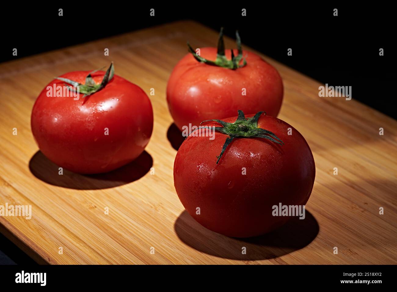 Pomodori rossi freschi fotografati su sfondo scuro Foto Stock