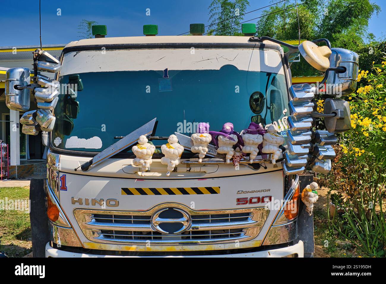 Davanti a un camion Hino Dominator 500, decorato con mascotte Michelin e dozzine di specchi retrovisori, Lom Sak, Thailandia Foto Stock