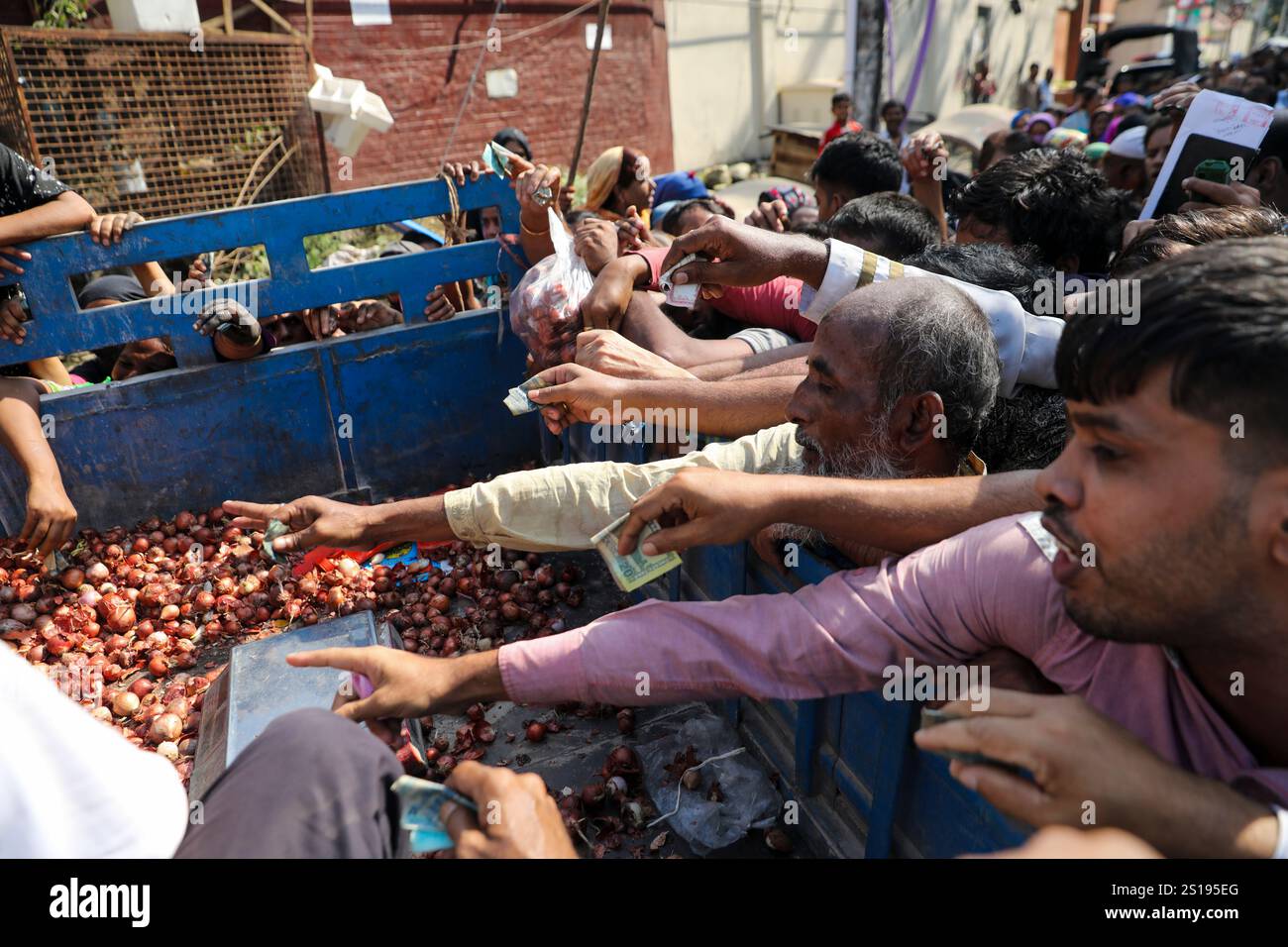 Dhaka, Bangladesh: Mentre i prezzi delle cipolle continuano a salire, gli individui a basso reddito si vedono scovare per acquistare l'oggetto essenziale da una società commerciale Foto Stock