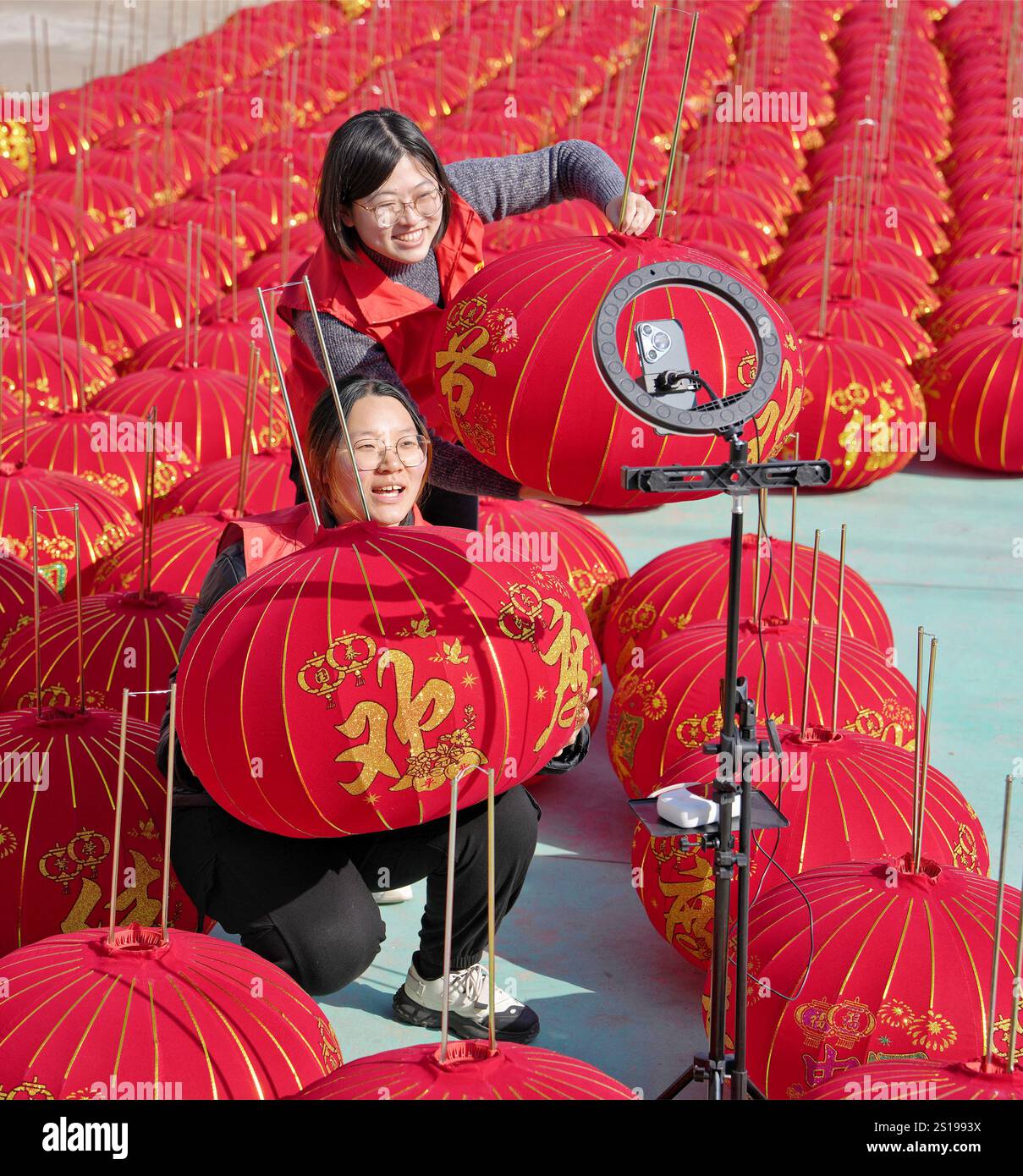 I volontari vendono lanterne rosse tramite trasmissione online presso un laboratorio di lavorazione delle lanterne nel villaggio di Maozhuang, Duntou Town, Haian, Jiangsu della Cina orientale Foto Stock