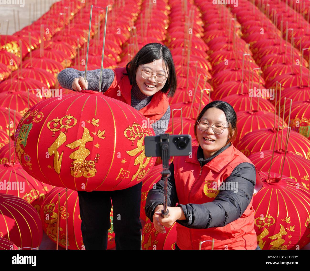 I volontari vendono lanterne rosse tramite trasmissione online presso un laboratorio di lavorazione delle lanterne nel villaggio di Maozhuang, Duntou Town, Haian, Jiangsu della Cina orientale Foto Stock