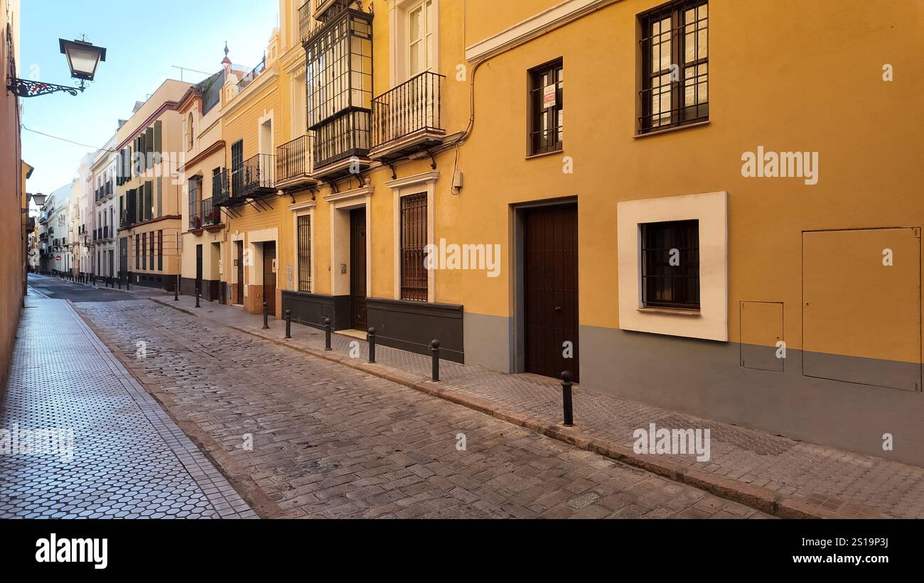 Una tranquilla e stretta strada laterale di Siviglia, Spagna, durante il giorno, con nessuno in giro Foto Stock