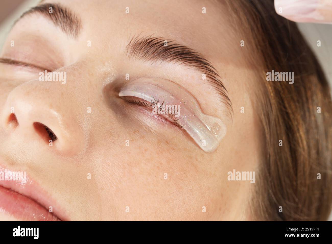 Procedura di laminazione delle ciglia. Donna con cuscinetto in silicone sulla palpebra nel salone di bellezza, primo piano Foto Stock