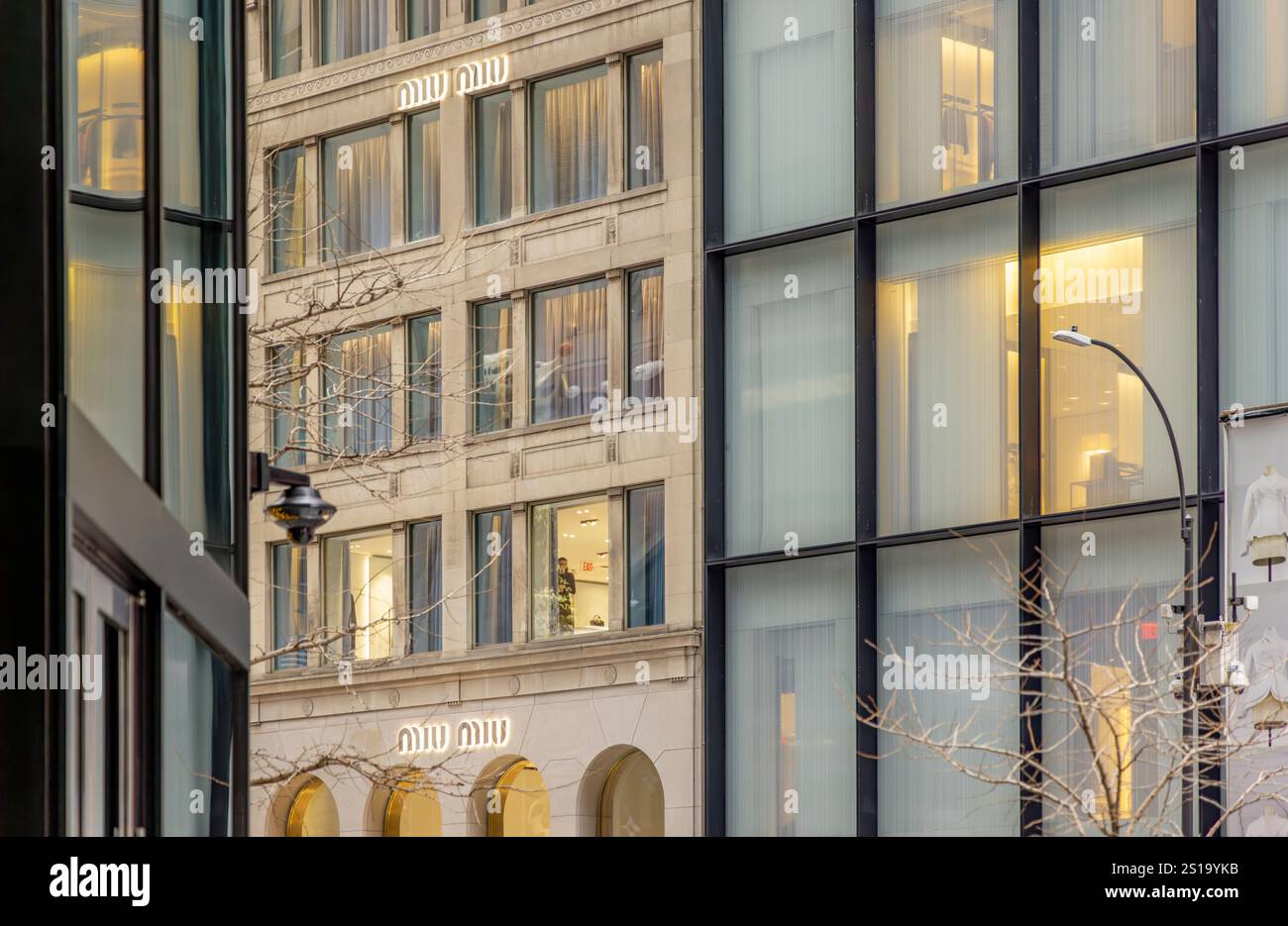 una donna che lavora in una finestra al secondo piano sulla 57esima strada est, new york Foto Stock
