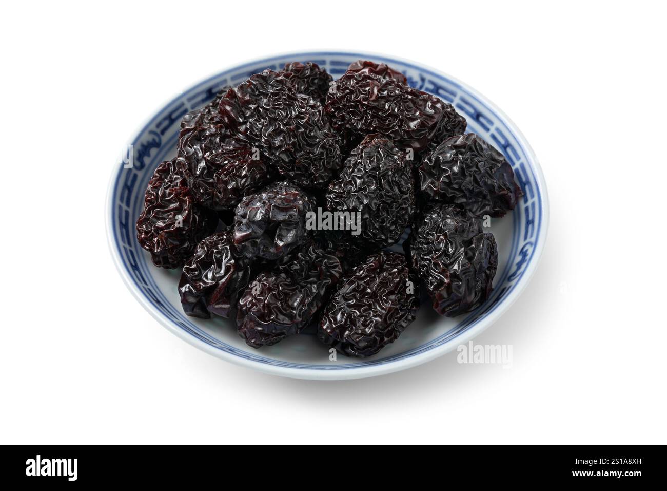 Ciotola con giubbotti cinesi neri affumicati essiccati, isolata su sfondo bianco da vicino Foto Stock