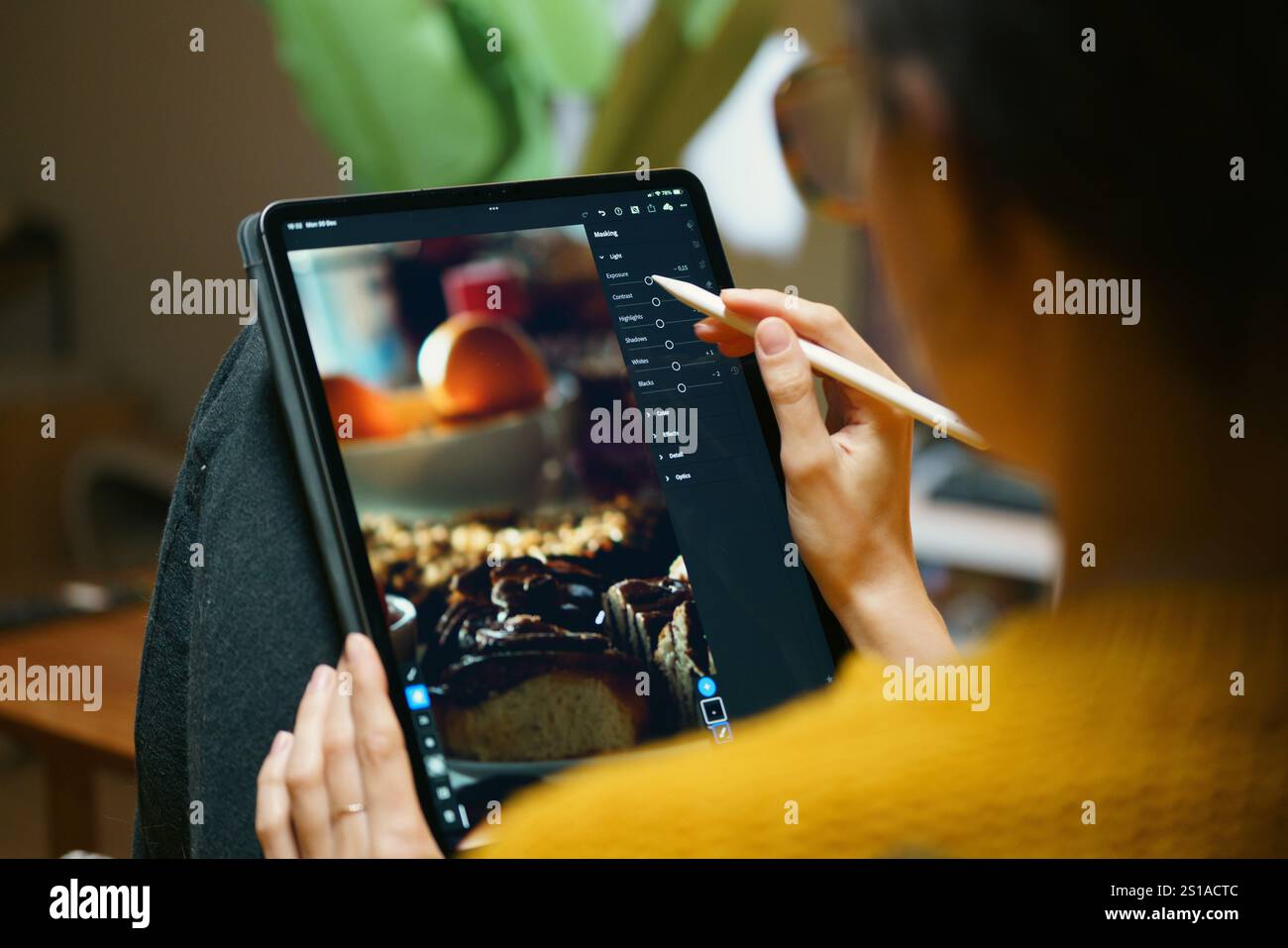 fotoritocco femminile su tablet grafico digitale software lightroom per rilassare gli interni del salotto di casa, lavorare come freelance Foto Stock