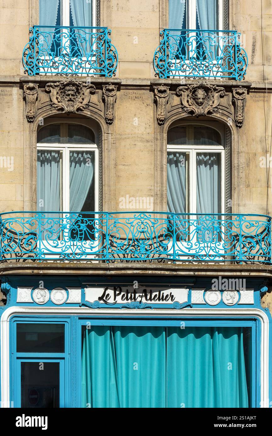 Francia, Meurthe et Moselle, Nancy, vetrina anteriore di un negozio e facciata di un condominio con ornamenti in mascaron che rappresentano volti umani e ringhiere per finestre in ferro battuto situato in Rue stanislas Foto Stock