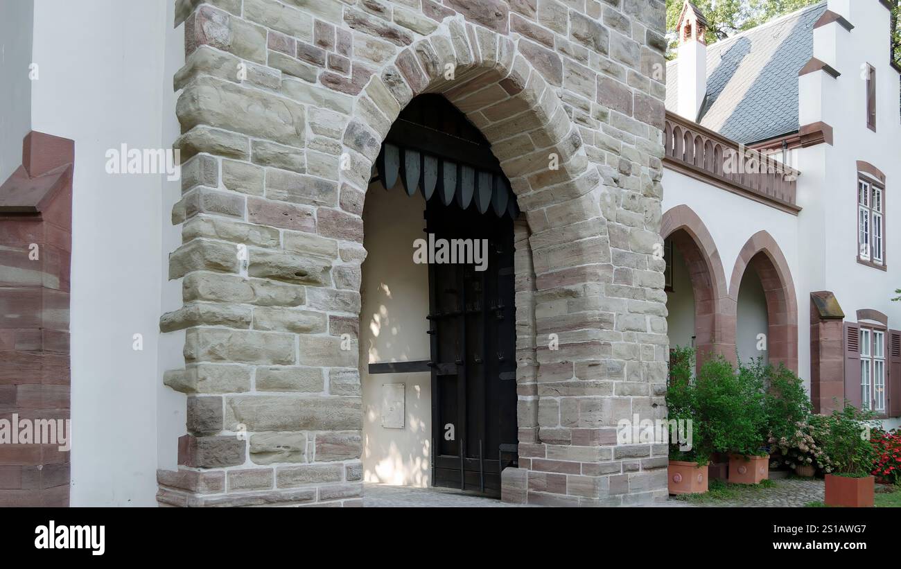 Storico ingresso ad arco in pietra di un edificio tradizionale con elementi decorativi Foto Stock
