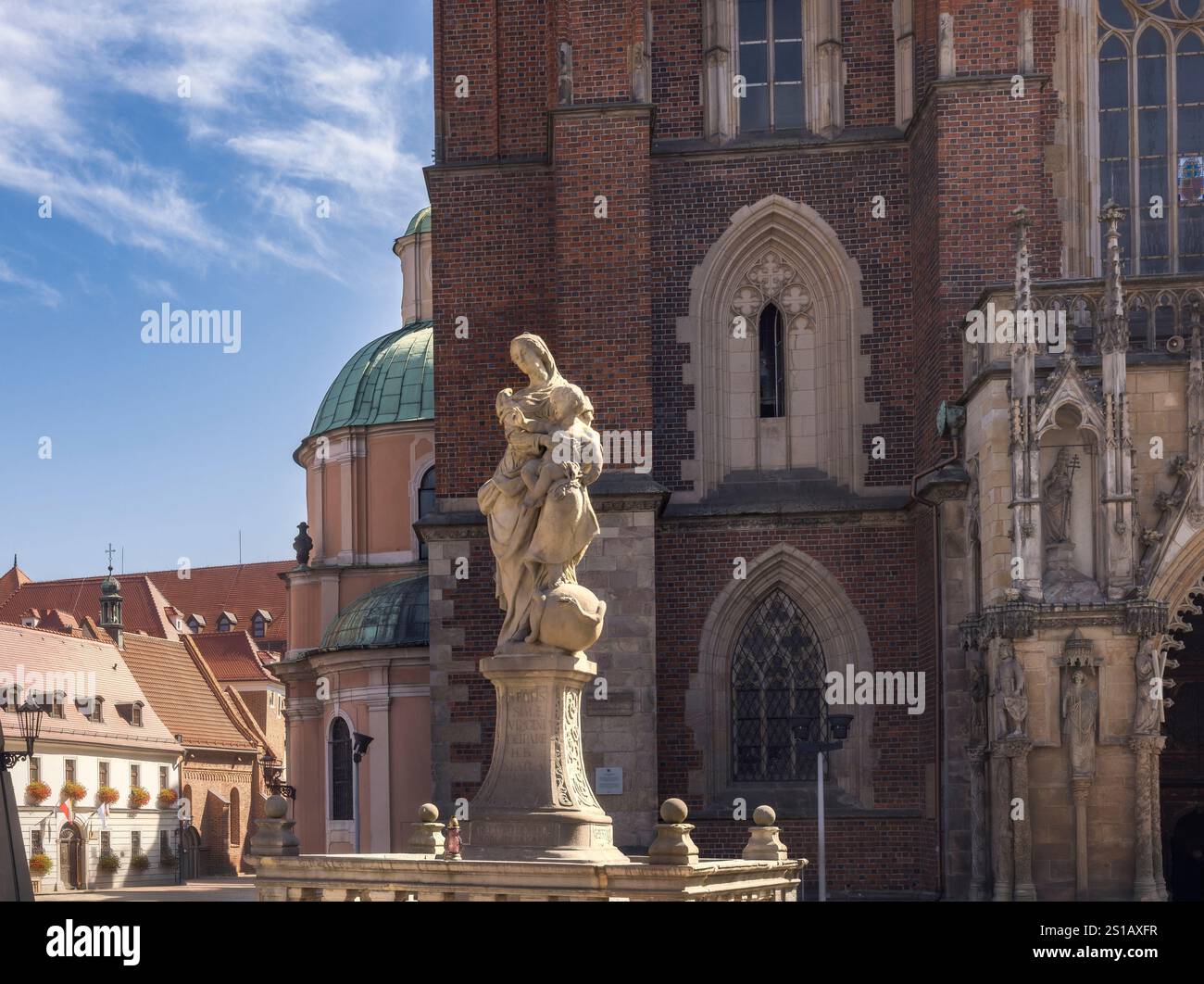 La splendida architettura della cattedrale di Breslavia presenta dettagli intricati e una maestosa statua contro un cielo blu, Polonia Foto Stock