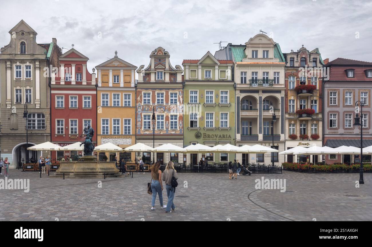 Gli edifici colorati fiancheggiano la Piazza del mercato Vecchia di Poznan mentre i visitatori apprezzano l'atmosfera vivace e i caffè all'aperto della Polonia Foto Stock