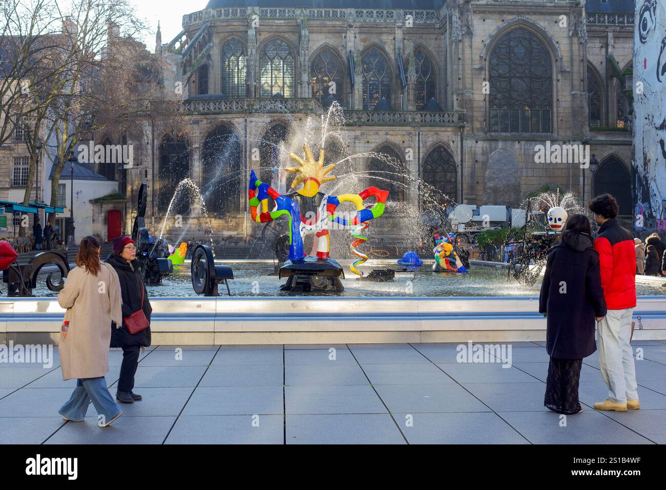 Parigi, Francia, 12.26.2024. Una coppia che guarda la fontana Stravinsky con sullo sfondo la Chiesa di San Merri Foto Stock