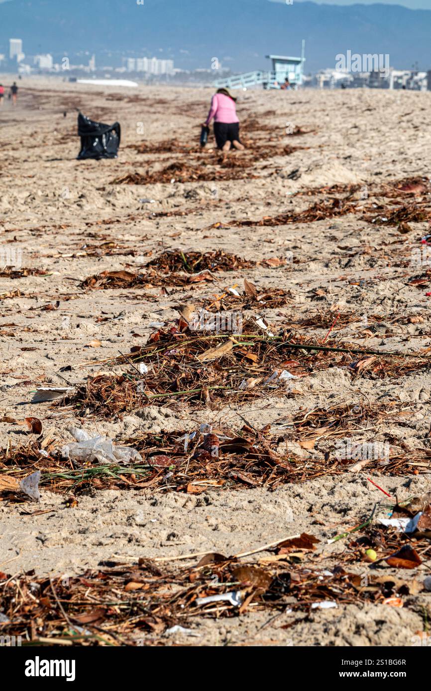 Un paio di residenti locali ripuliscono spazzatura e plastica sulla spiaggia di Playa del Rey che hanno lavato il giorno dopo che la tempesta tropicale Hilary ha colpito Los Angeles. U.S. Foto Stock