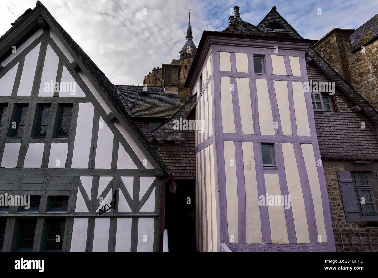 160 Mont-Saint-Michel. Telai a metà legno su facciate bianche e verdi, color crema e viola delle case XV c.viste dal passaggio pedonale dei bastioni. Normandia-Francia. Foto Stock