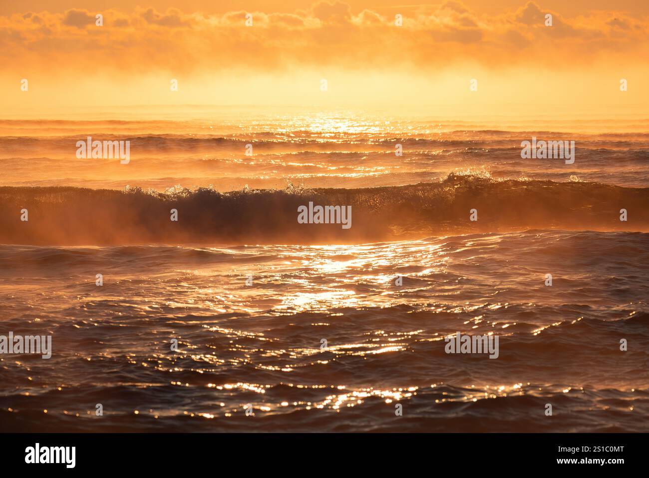 Golden Sunrise Over Ocean Waves con un sereno orizzonte Foto Stock