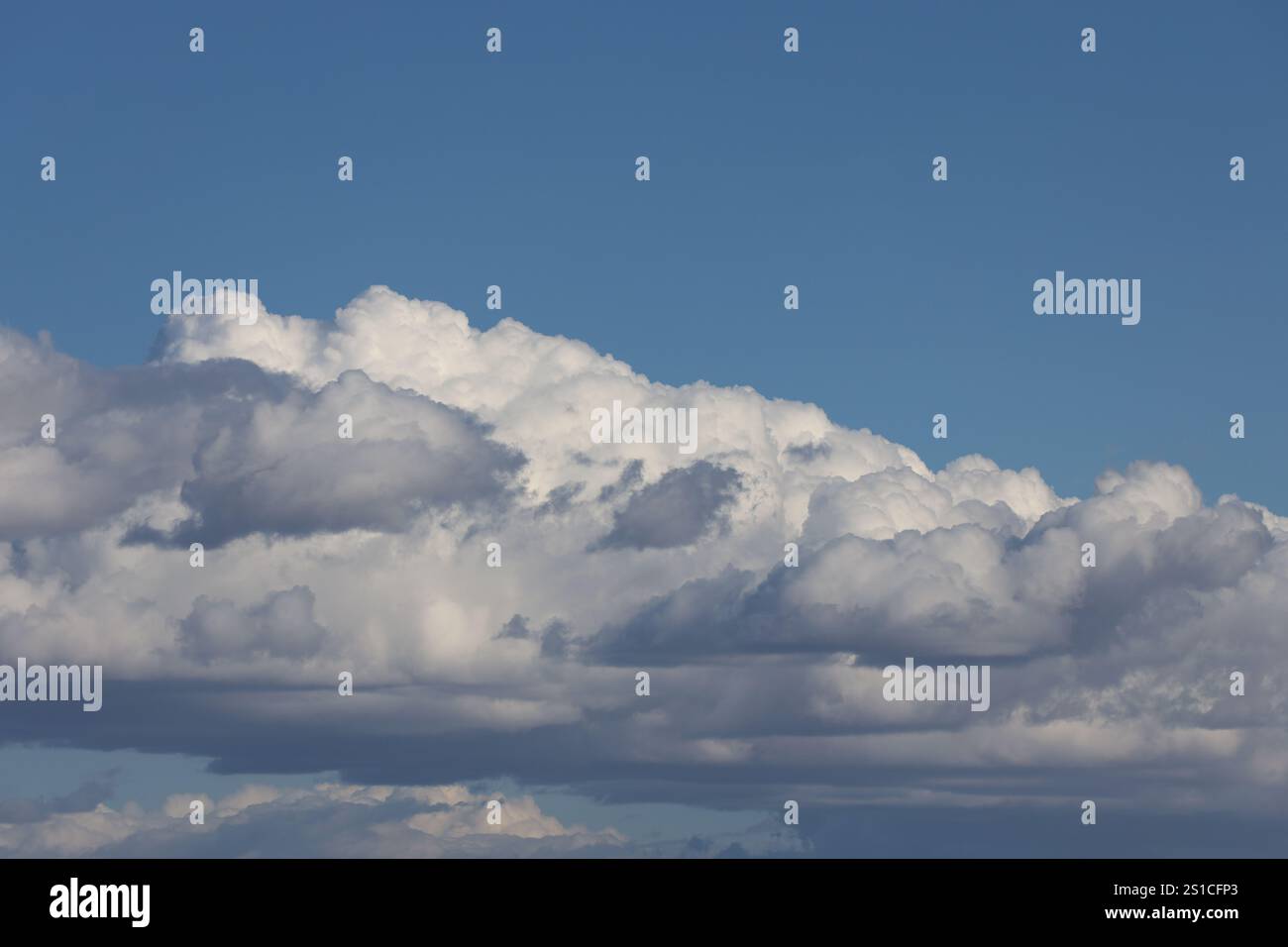 soffici nuvole bianche catturano il sole sopra le nuvole grigie più scure sottostanti Foto Stock