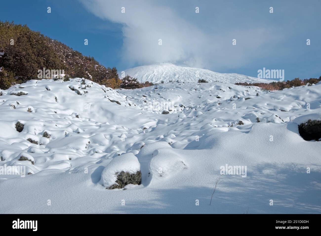 Campo di lava innevato e Etna nel Parco dell'Etna, Sicilia, Italia Foto Stock