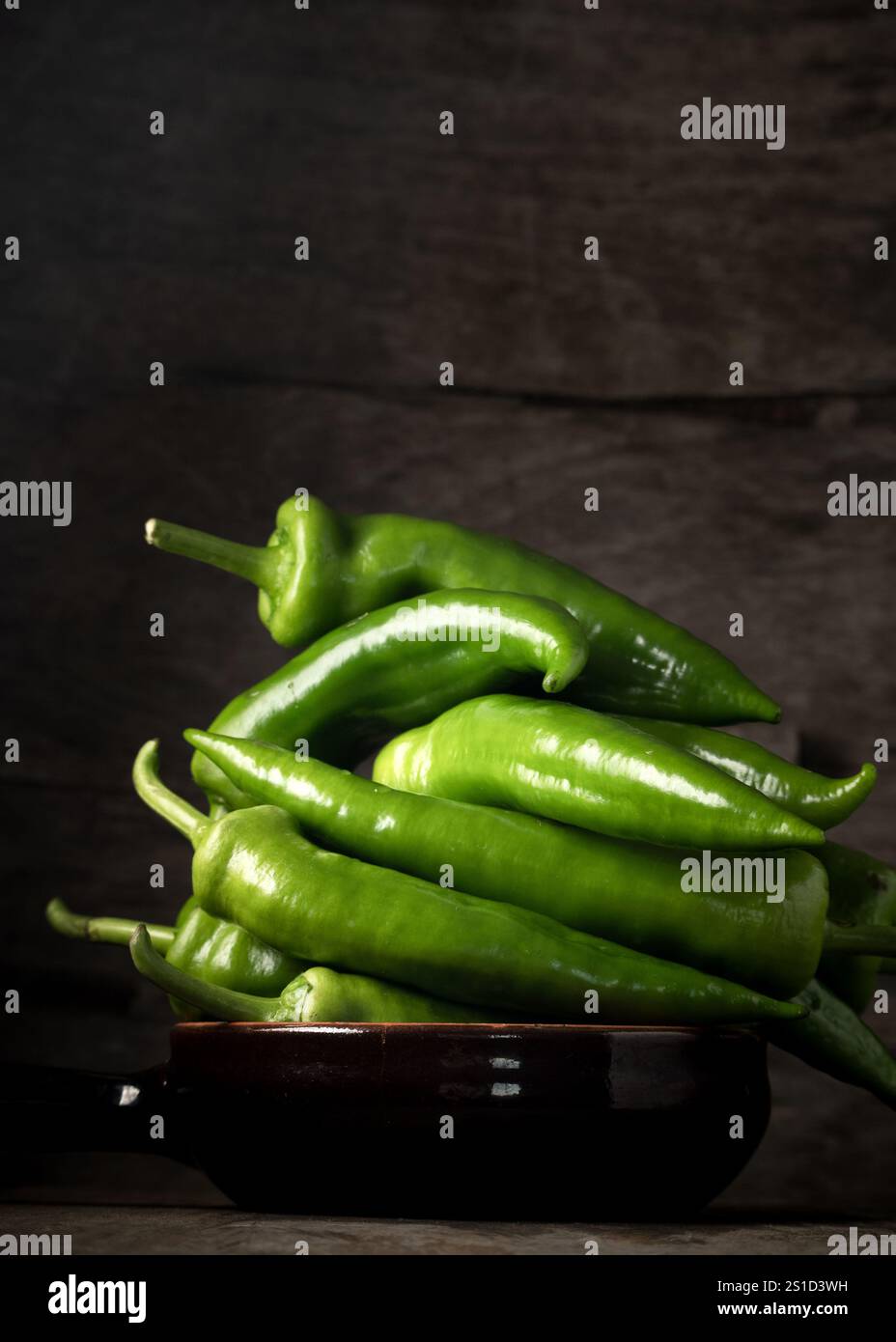 Peperoni verdi freschi crudi in tavola, ingredienti alimentari genuini, concetto agricolo Foto Stock