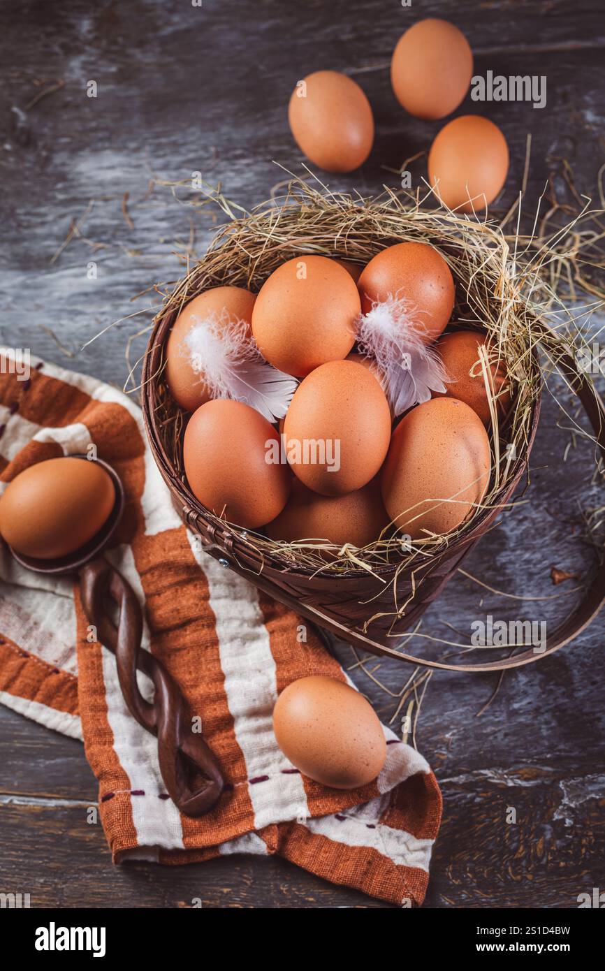 Uova biologiche di colore marrone in un cestino sul tavolo da cucina Foto Stock