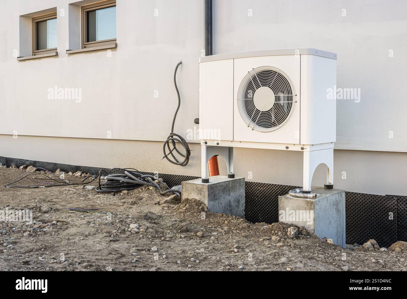 Pompe di calore a sorgente d'aria installate all'esterno di una nuova e moderna casa di città in costruzione, concetto di energia rinnovabile verde della pompa di calore Foto Stock