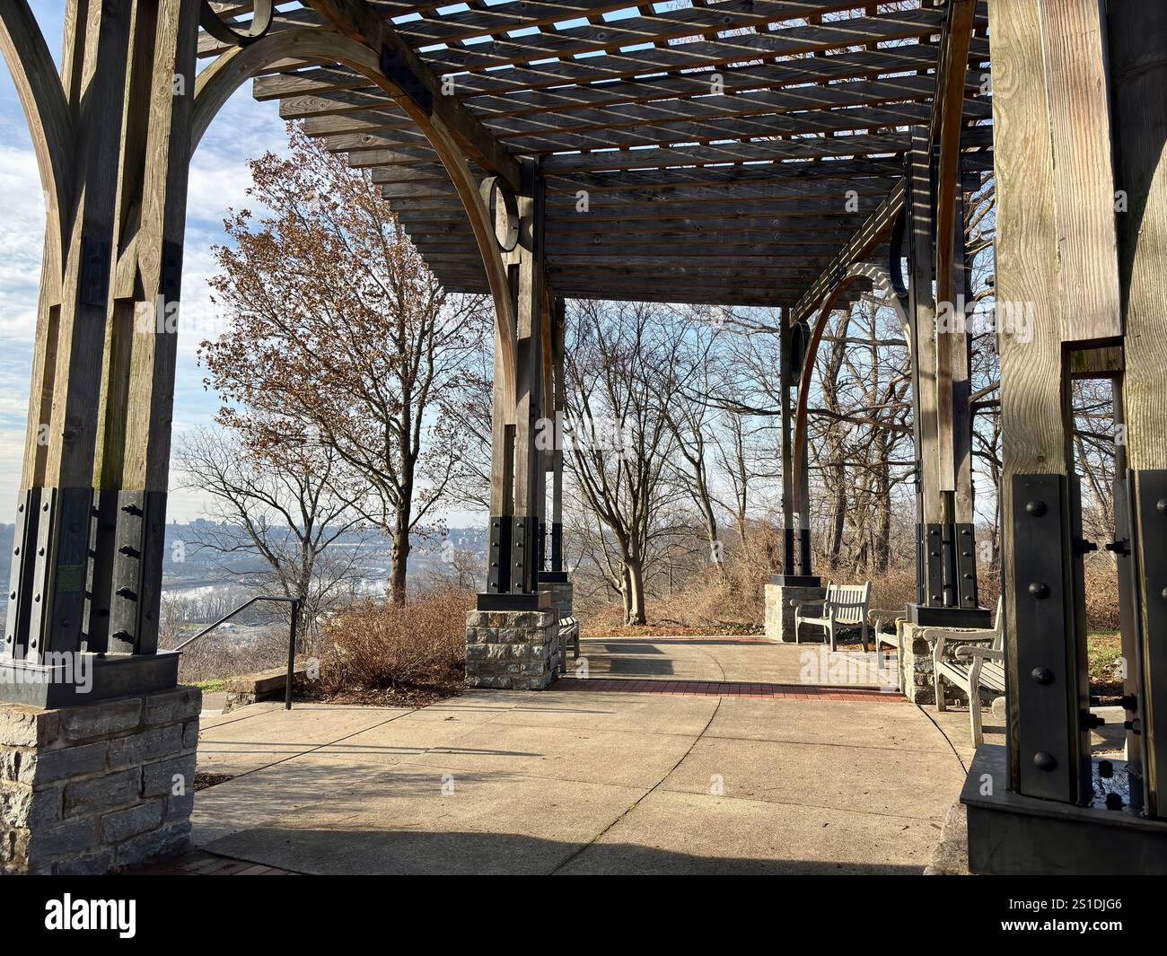 Pergola in legno con pilastri in pietra, panchine nel parco Foto Stock
