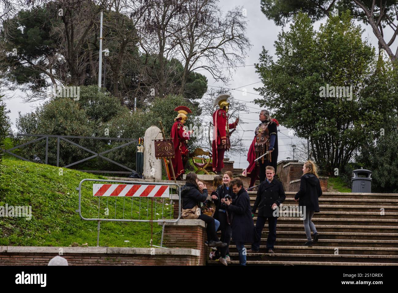 Roma, Italia - 11 febbraio 2013. Gli uomini vestiti da soldati romani si lasciano fotografare dai turisti a pagamento nel foro Romano. Foto Stock